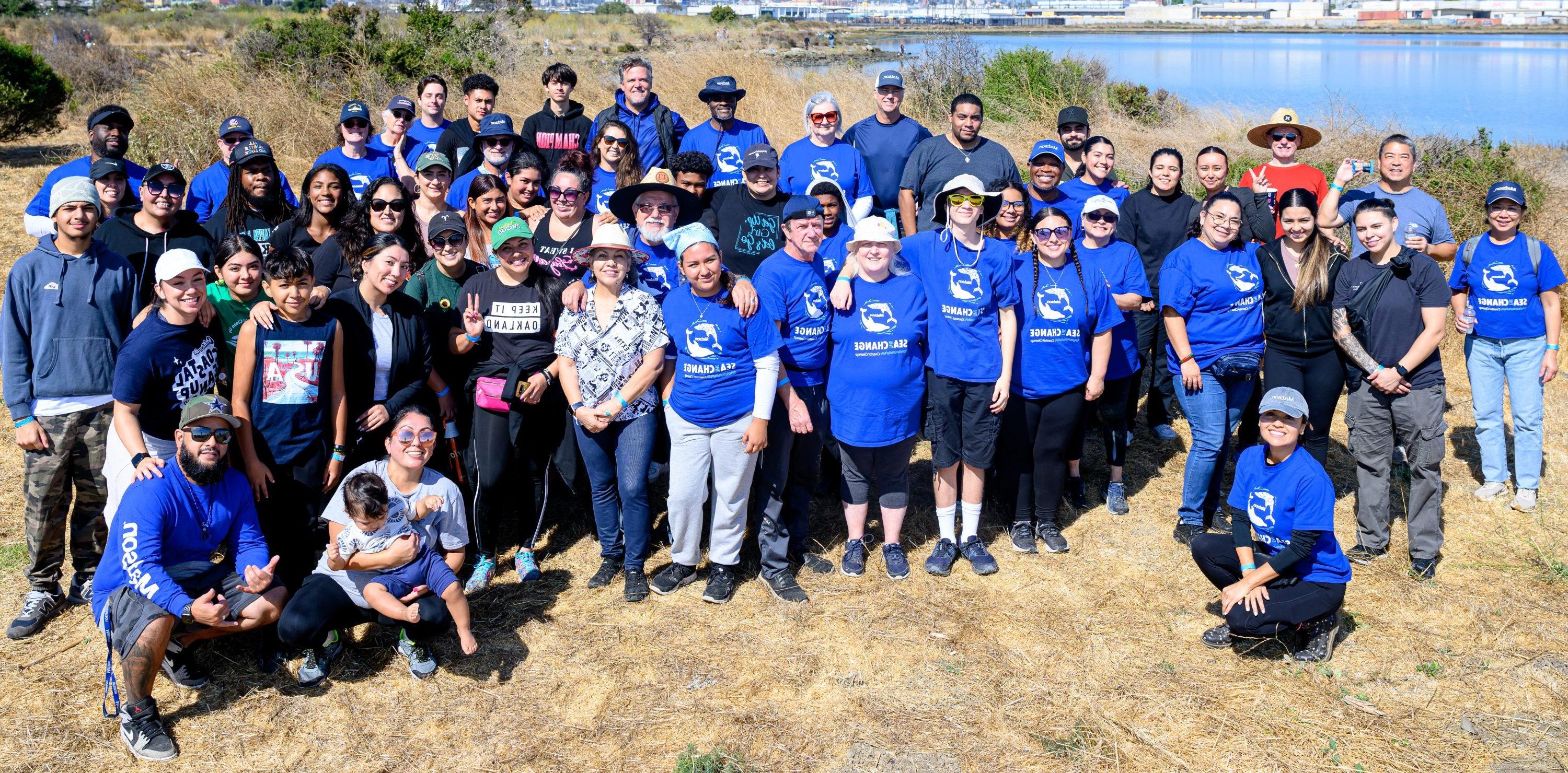 Team 澳博体育app下载 poses for a picture along the coastline of the Oakland Estuary.